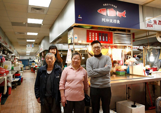 设计师冯宇为大直市场阿坤现捞鱼所设计招牌,并与商家合影